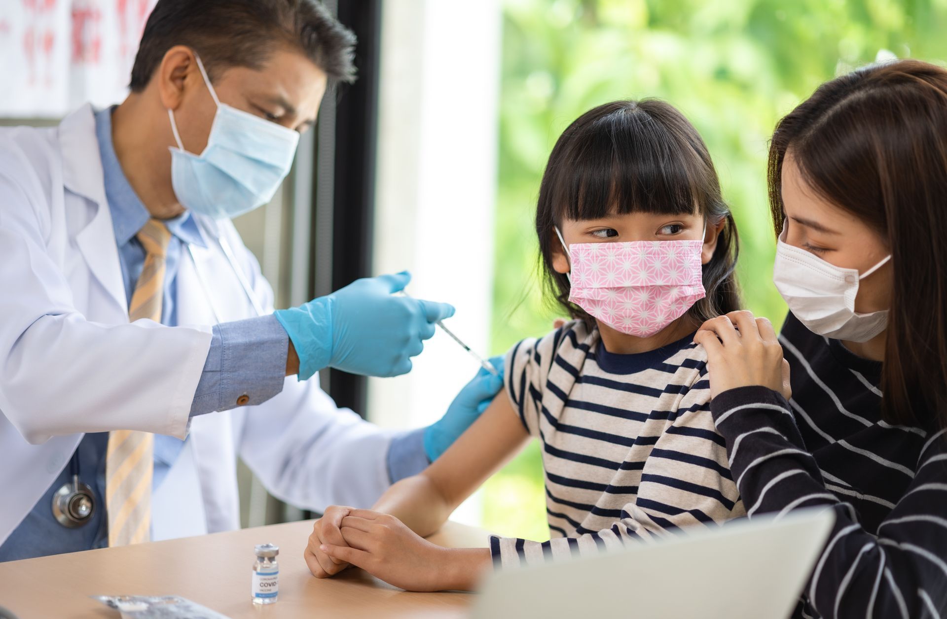 A Healthcare professional administering a vaccine to a child in a clinical setting.