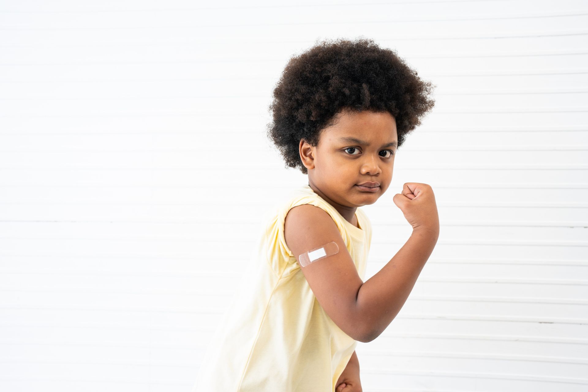 Child reveals bandaged shoulder after receiving vaccine at pediatric clinic Child reveals bandaged shoulder after receiving vaccine at pediatric clinic