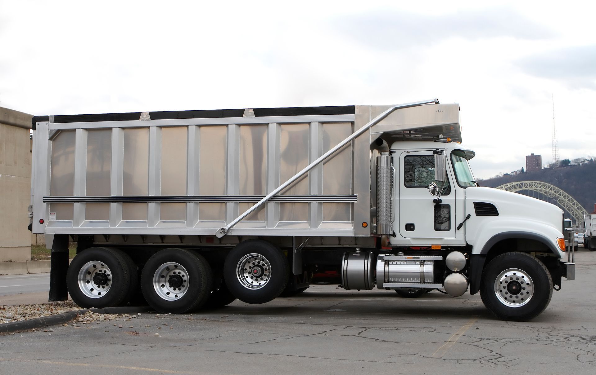 White dump truck with silver bed on pavement.