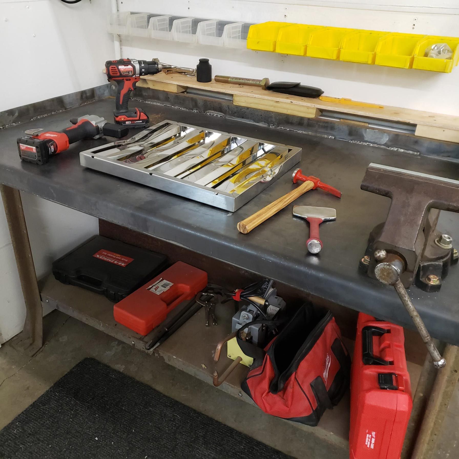 A workbench filled with tools and a toolbox that says ' milwaukee ' on it