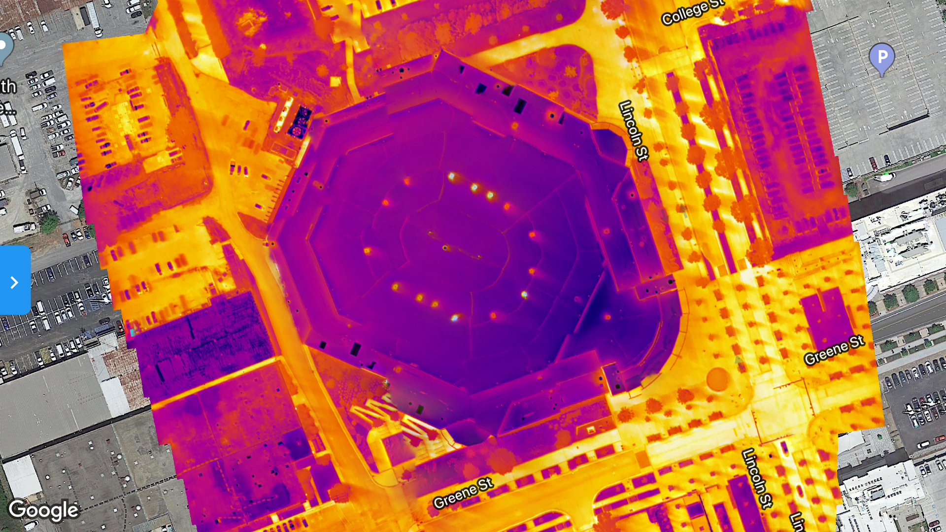 Woman in straw hat smiles, holding wine glass near a lake.