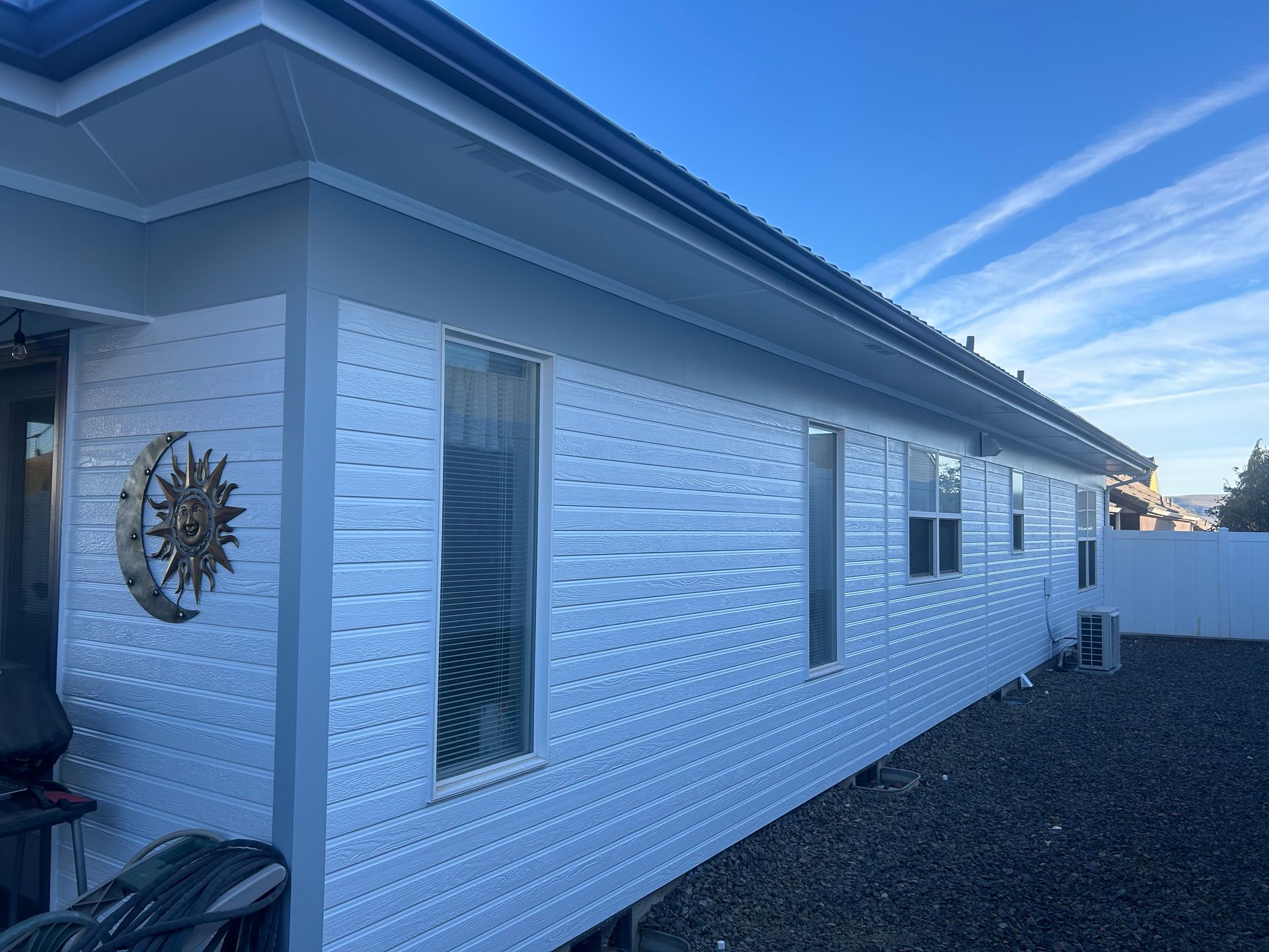 A white house with a sun and moon on the side of it.