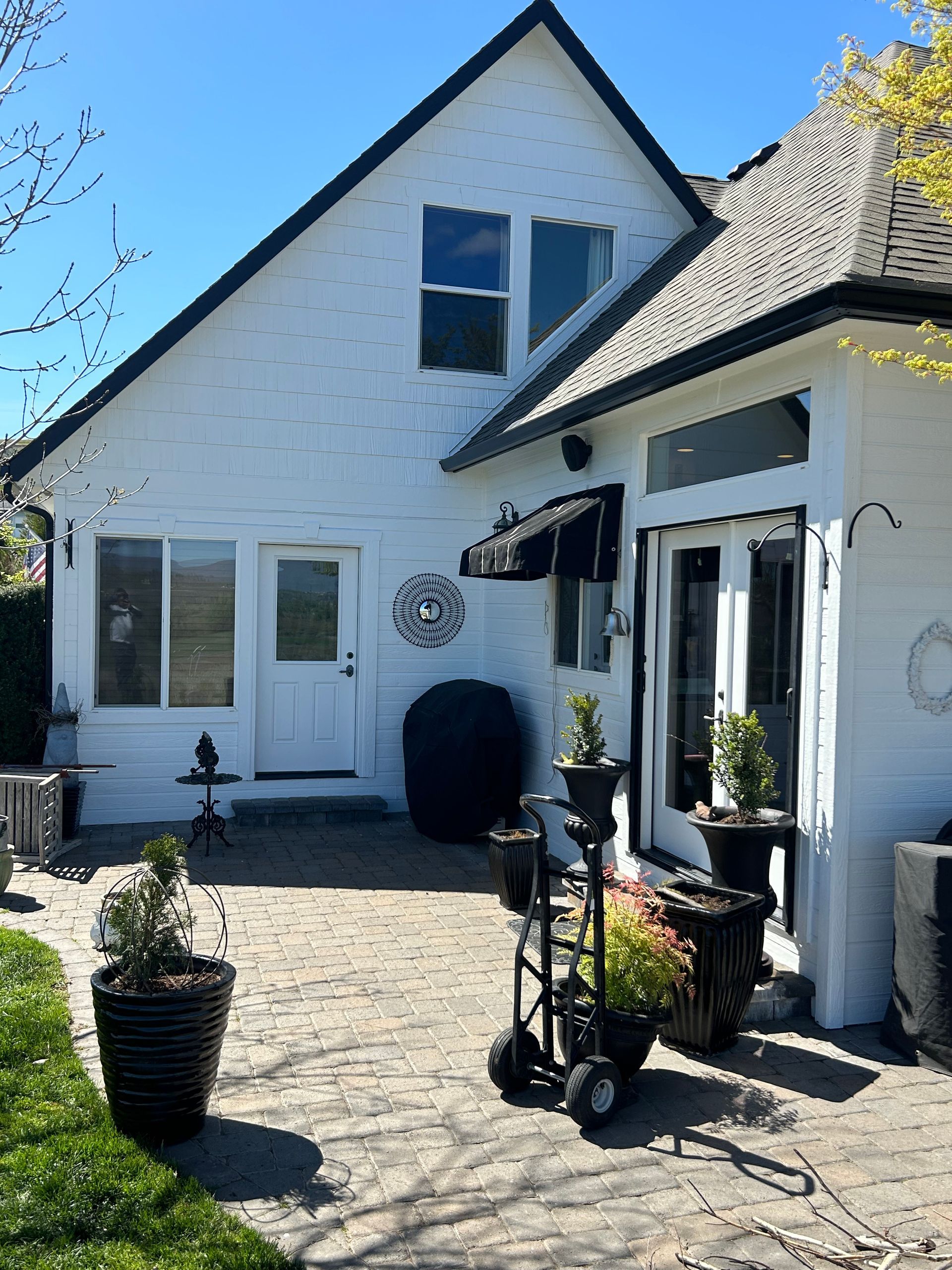 A white house with potted plants in front of it