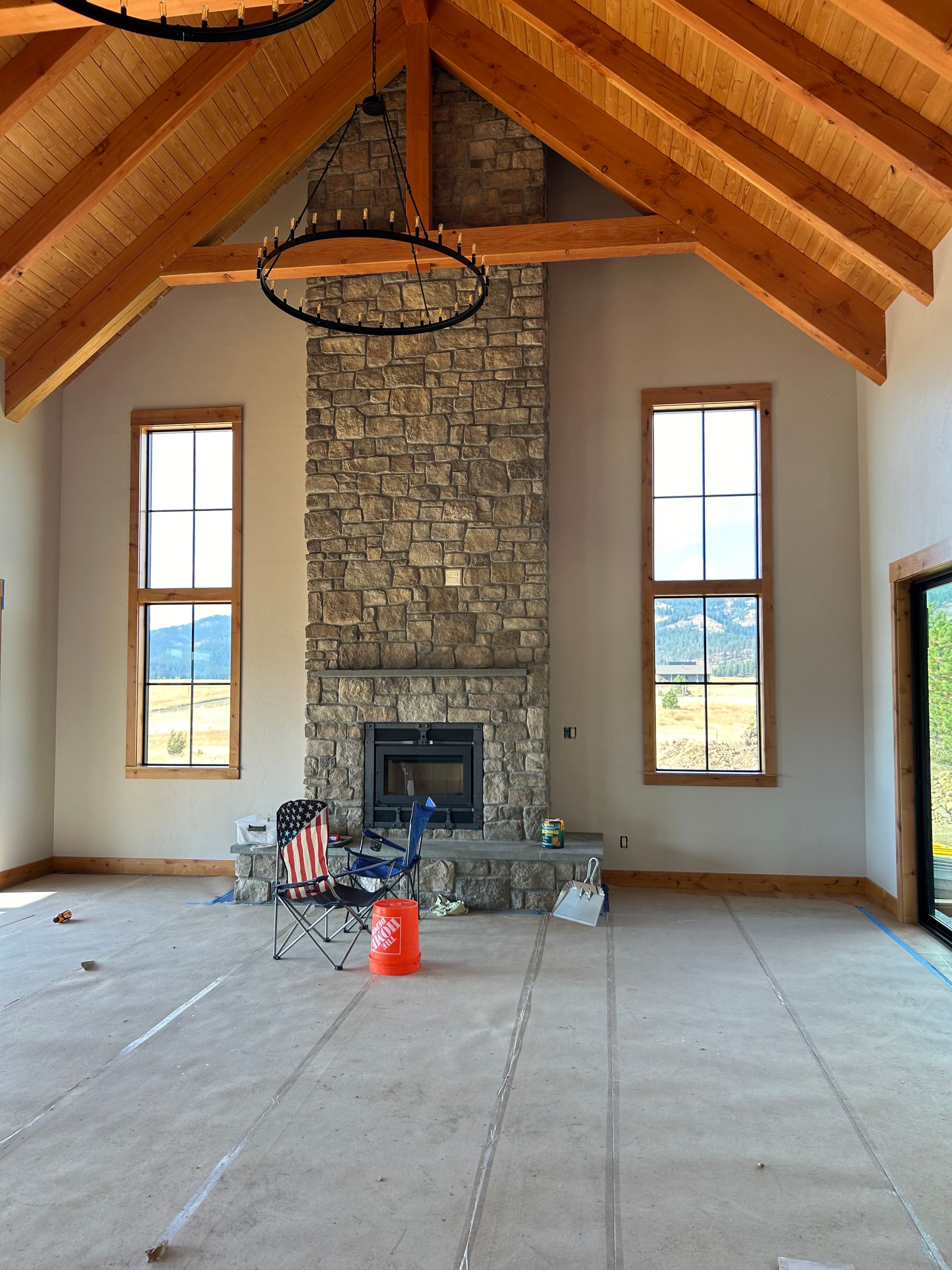 A large room with a stone fireplace and windows