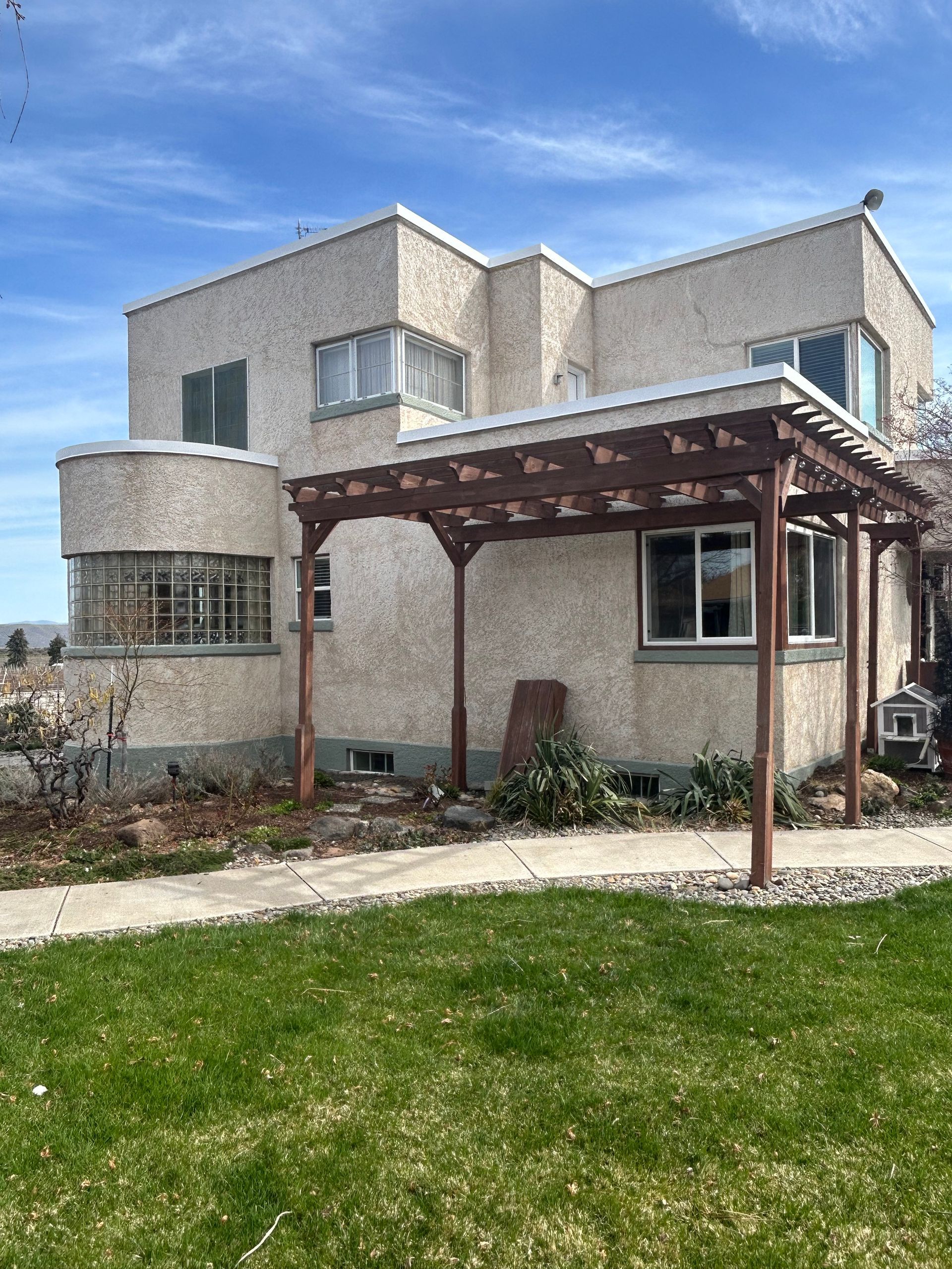 A large house with a pergola in front of it.