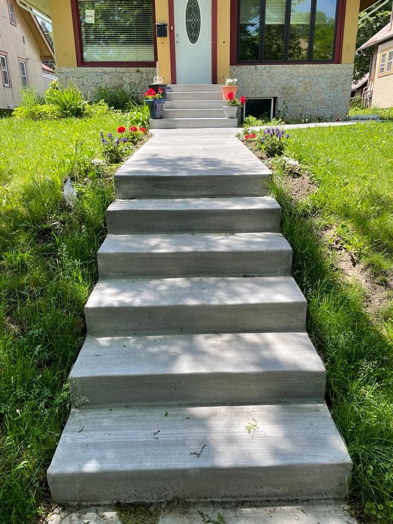 A set of concrete stairs leading up to a house.
