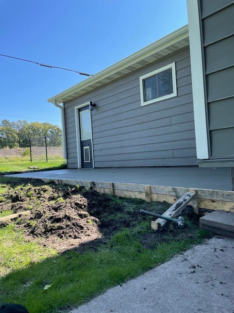 A house with a concrete porch and a hammer in front of it.