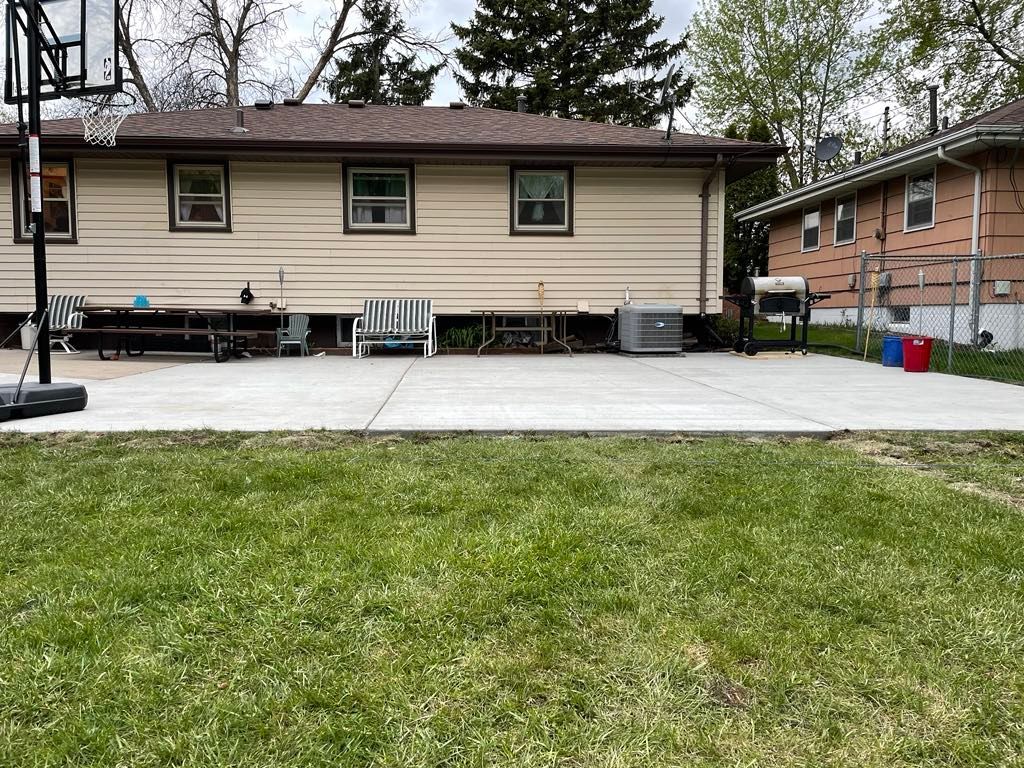 There is a basketball hoop in the backyard of a house.