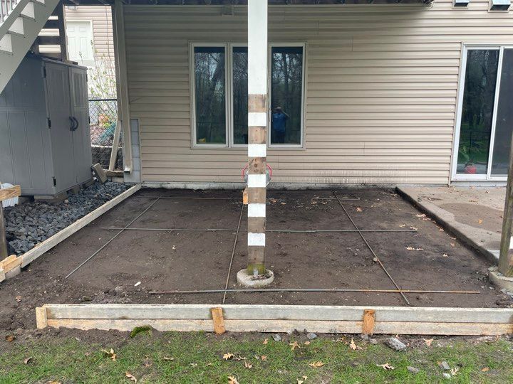 A concrete patio is being built in front of a house.