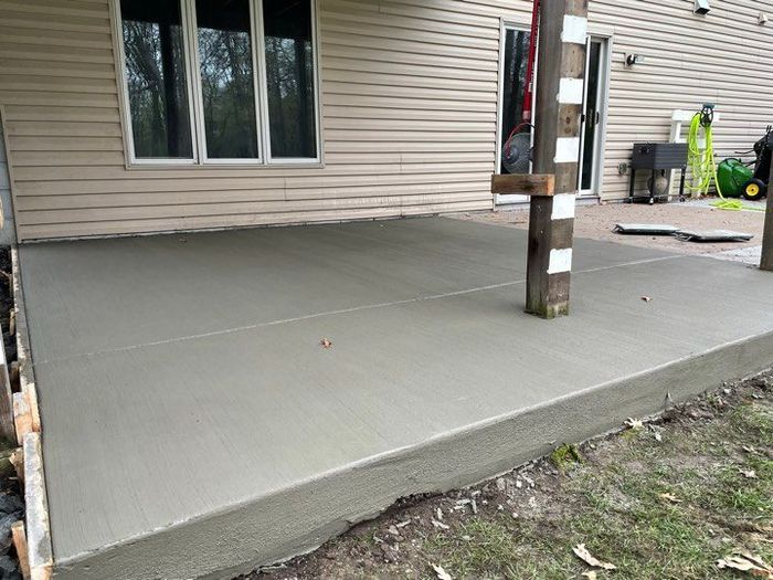 A concrete patio is being built in front of a house.