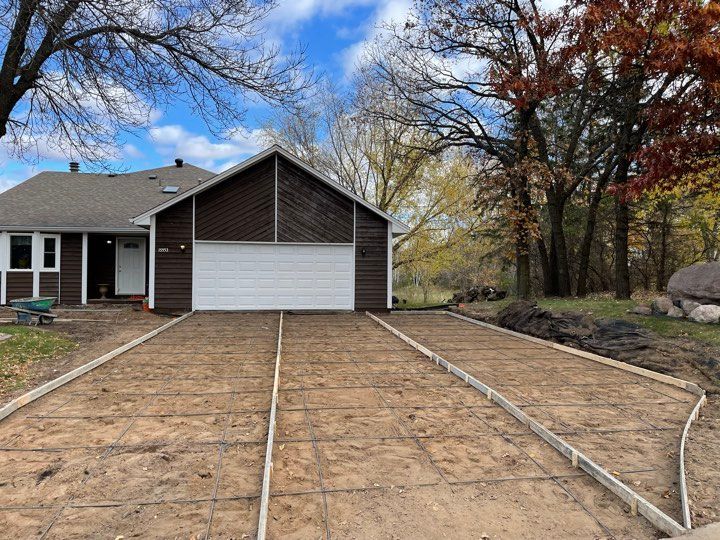 A house with a concrete driveway in front of it.