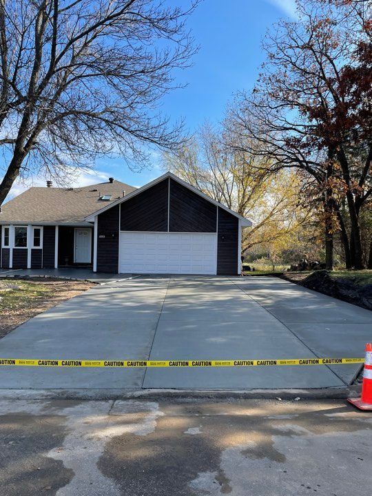 A concrete driveway is being built in front of a house.