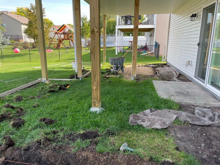 A covered patio is being built in the backyard of a house.