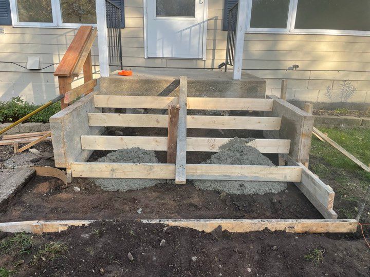 A concrete staircase is being built in front of a house.