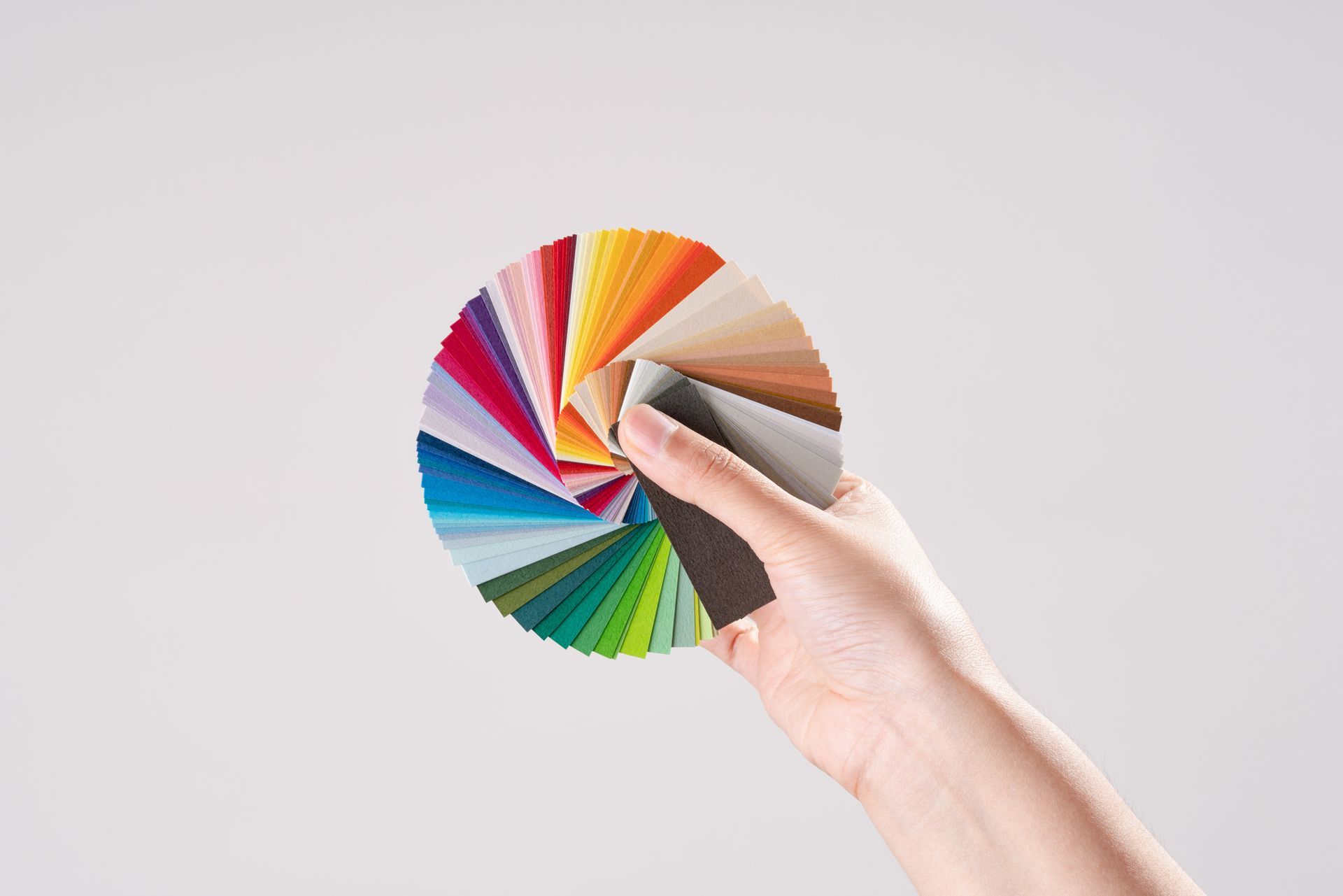 A person is holding a fan of different colors in their hand.