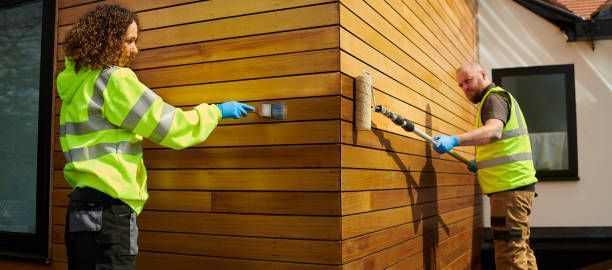 A man is painting a wall in a room with a roller.