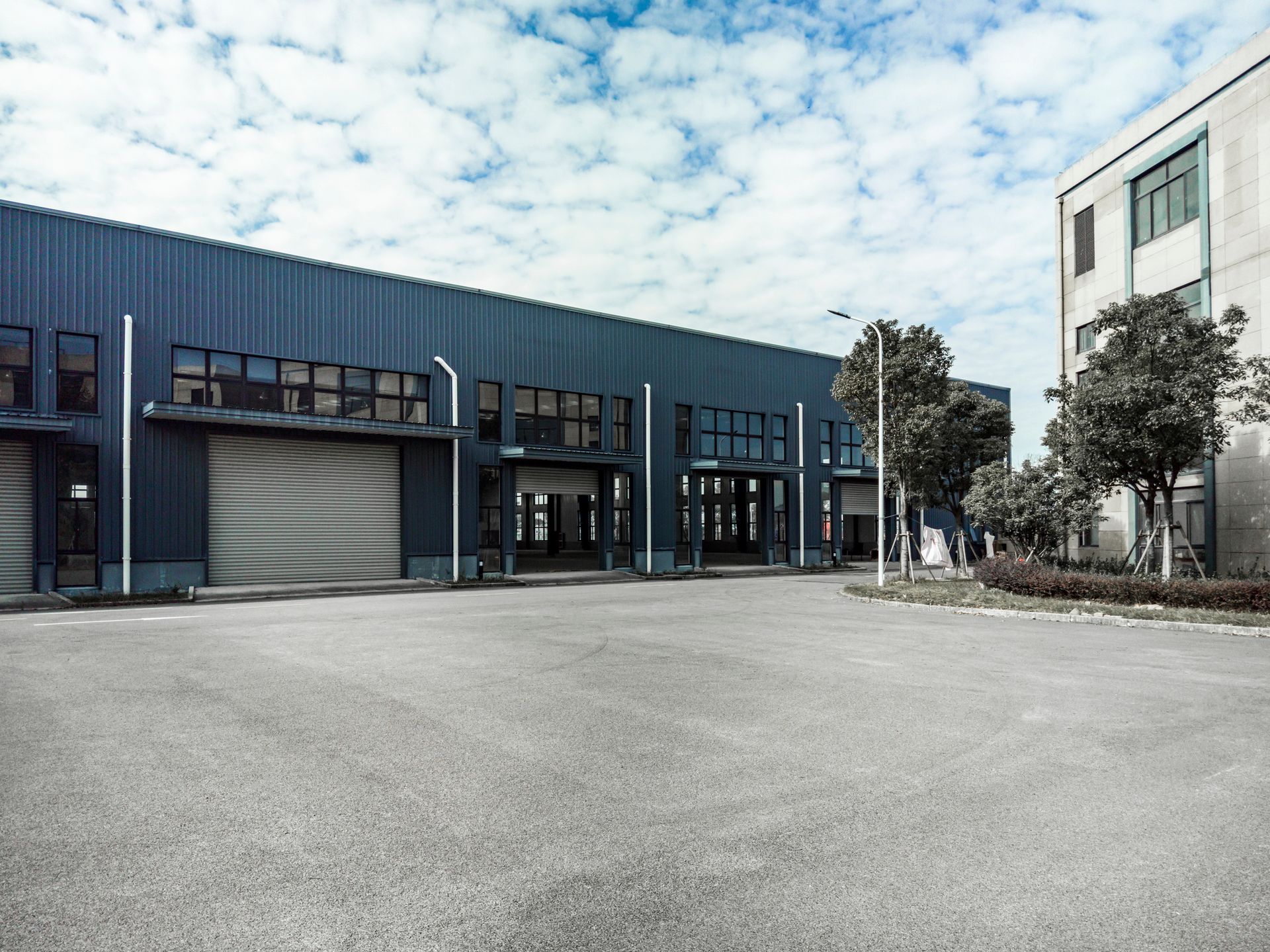 A large building with a lot of windows and a parking lot in front of it.