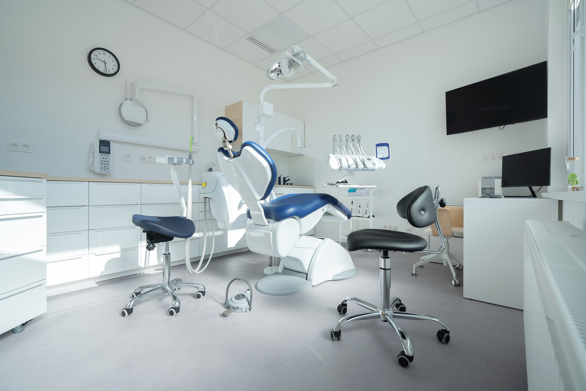 A dental office with a dental chair and chairs.