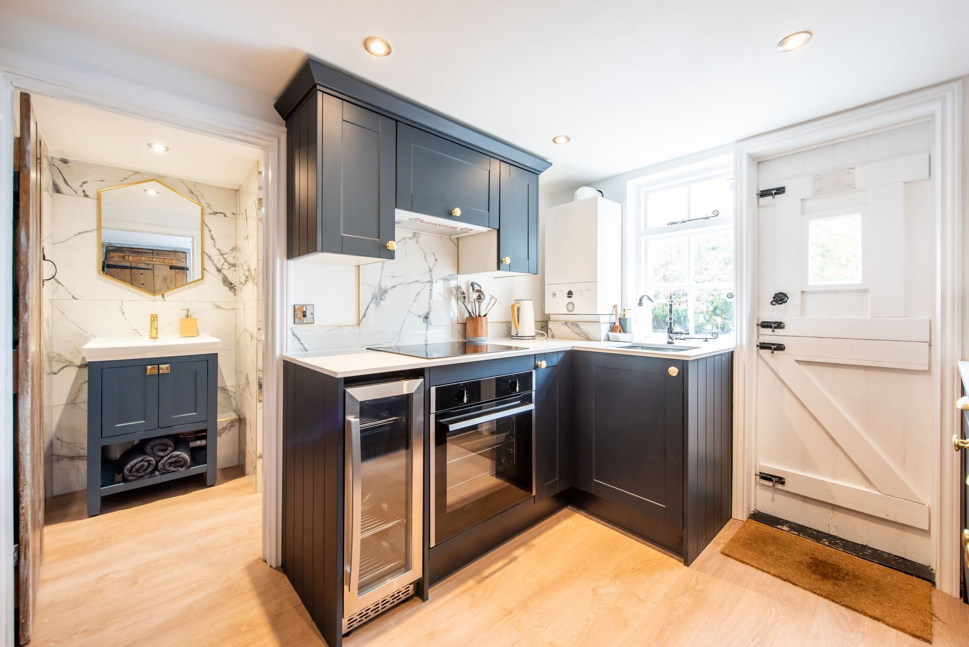 A kitchen with black cabinets and a stainless steel refrigerator.