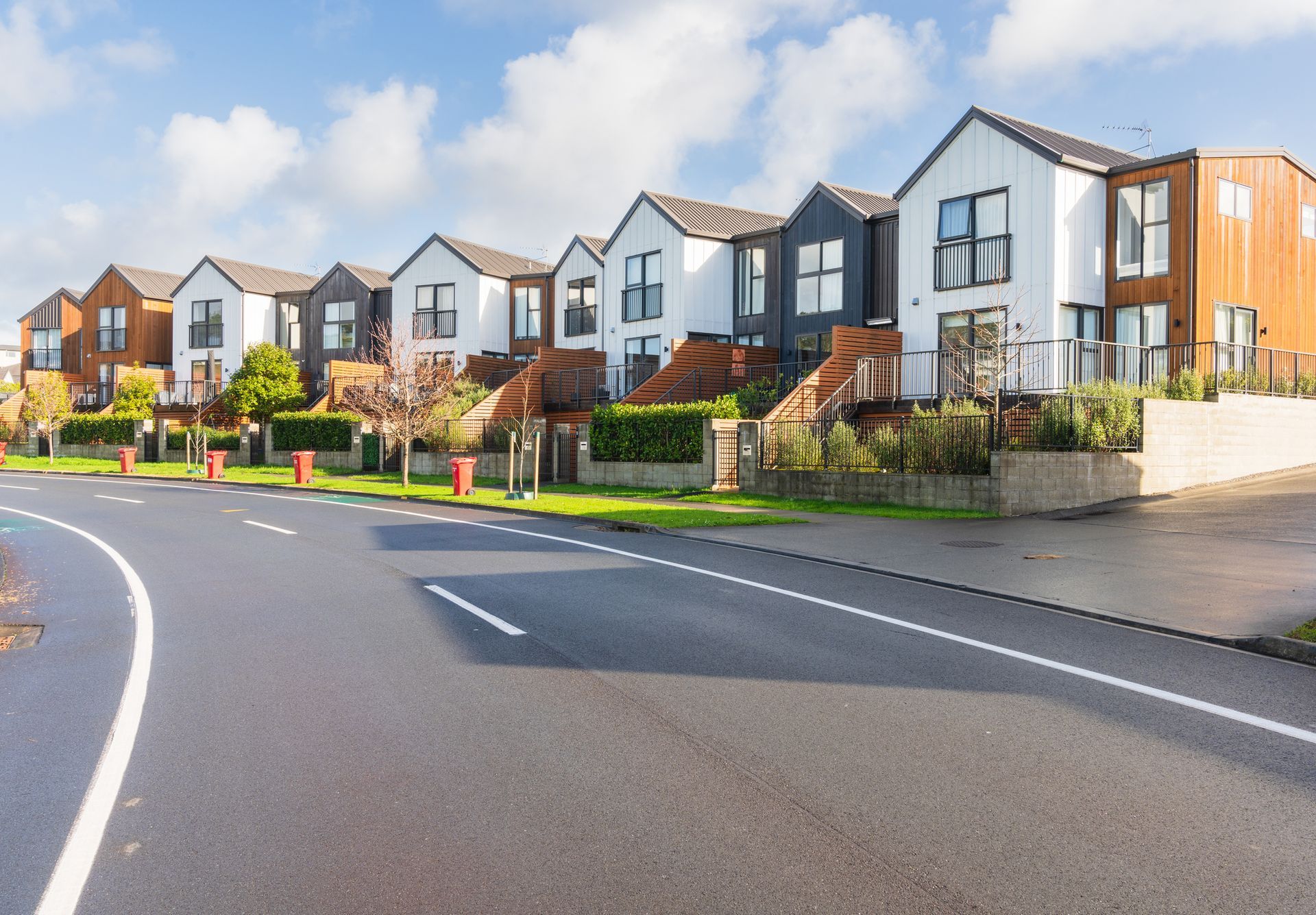 A row of houses are lined up on the side of a road.