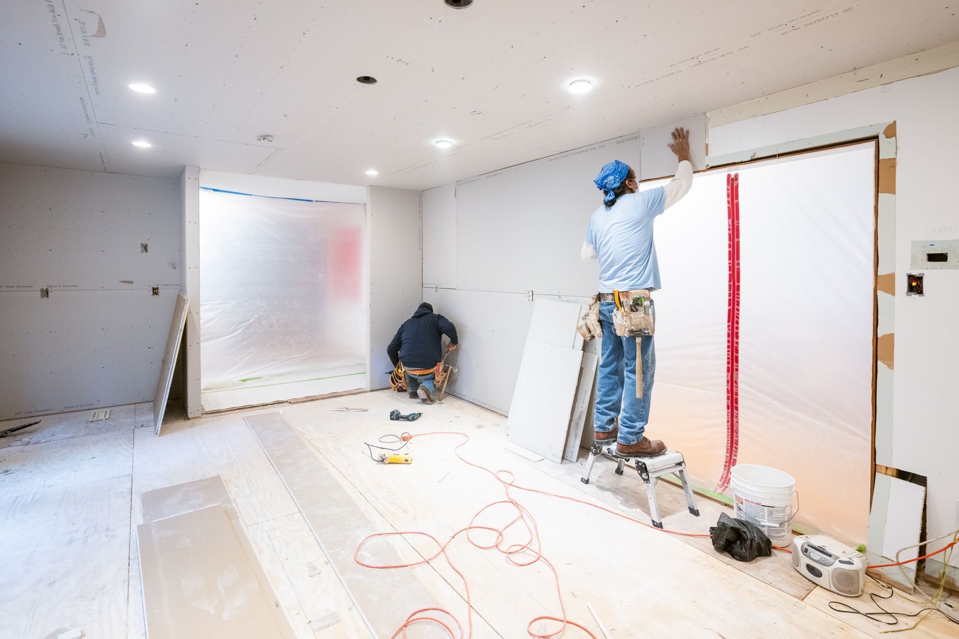 A man is standing on a ladder in a room.