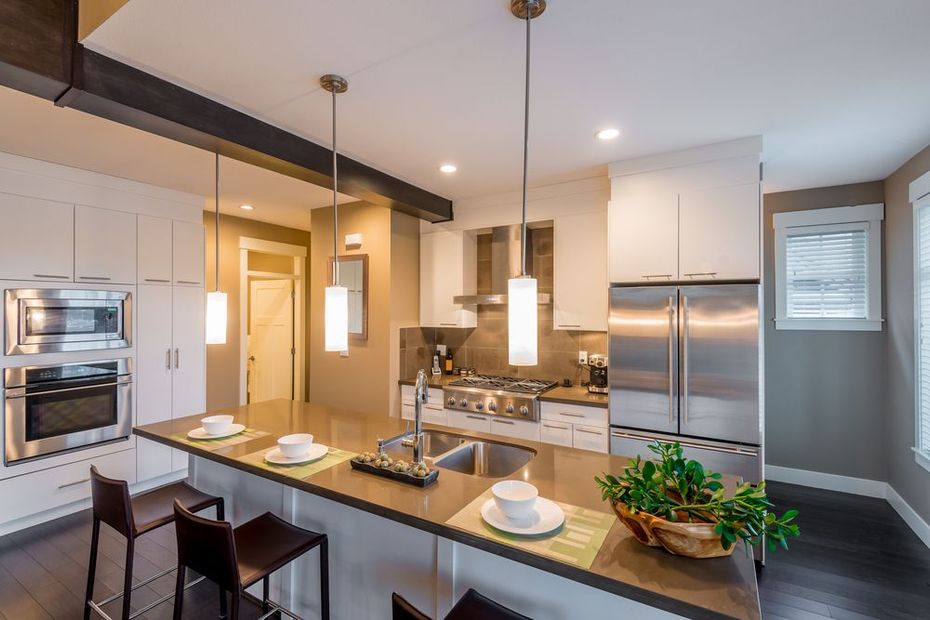 A kitchen with stainless steel appliances and white cabinets