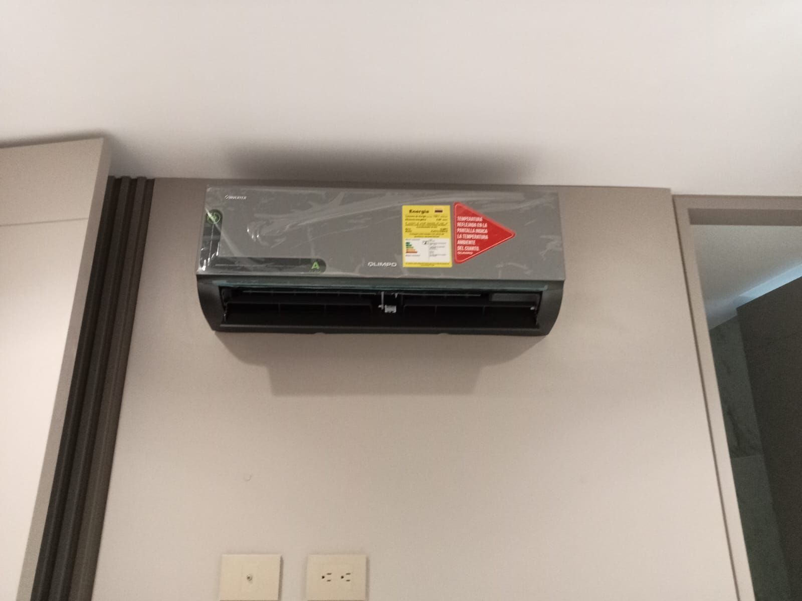 Un acondicionador de aire montado en la pared con una etiqueta.