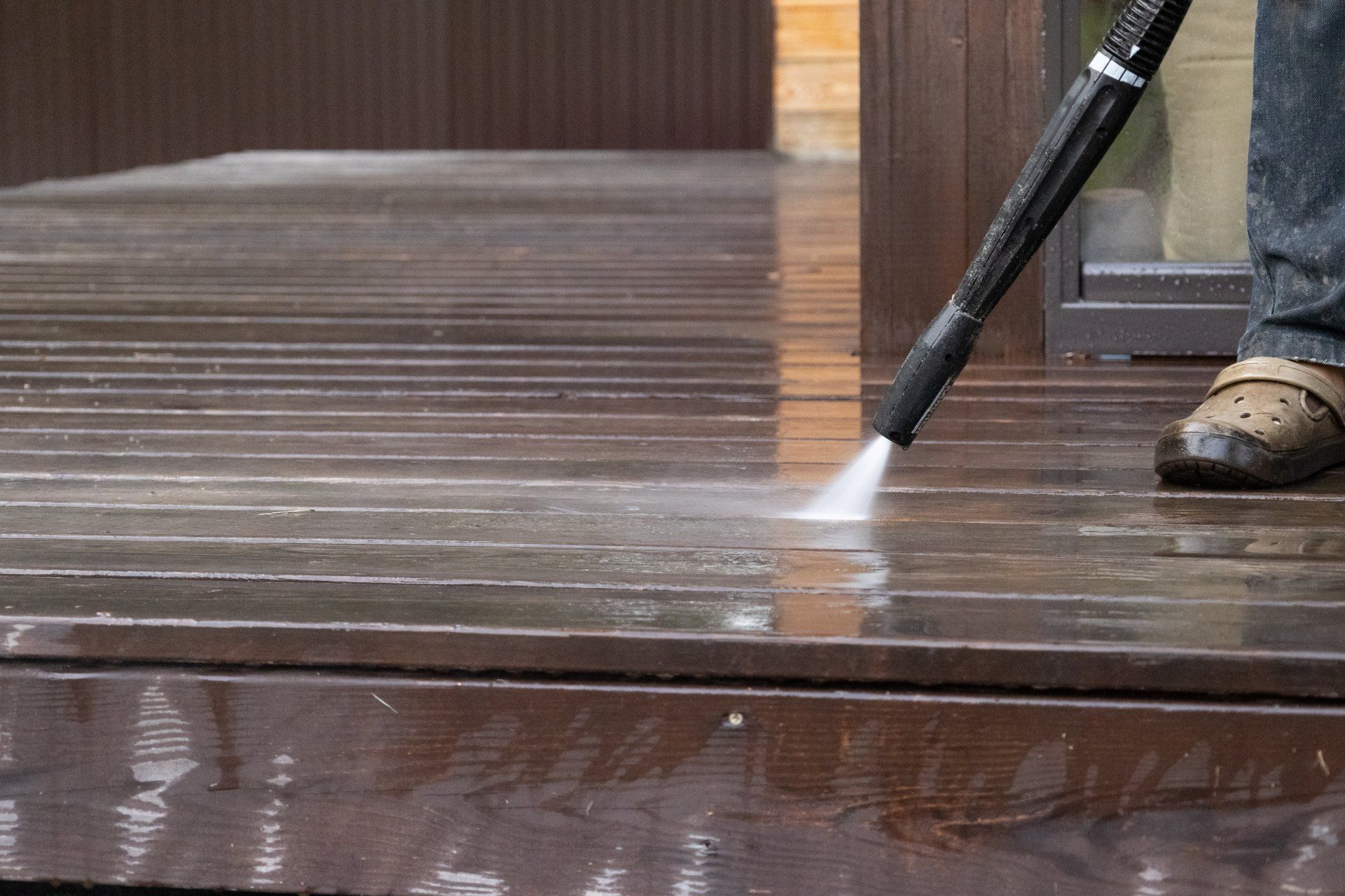 pressure washing wooden deck on Northwest Arkansas with pressure washer