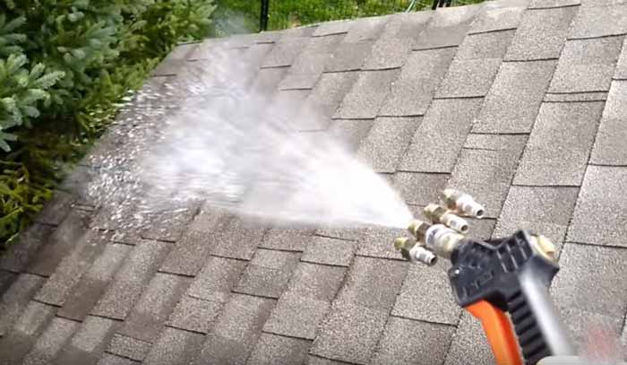 picture of pressure washing gun with soft washing equipment attached spraying rooftop in Rogers, AR