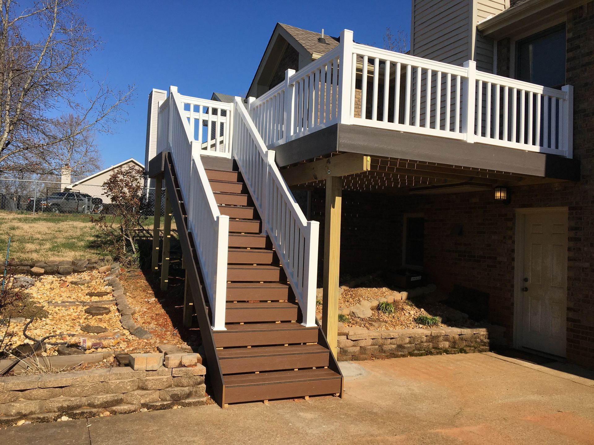 Brown and white deck with stairs leading up to a raised platform.