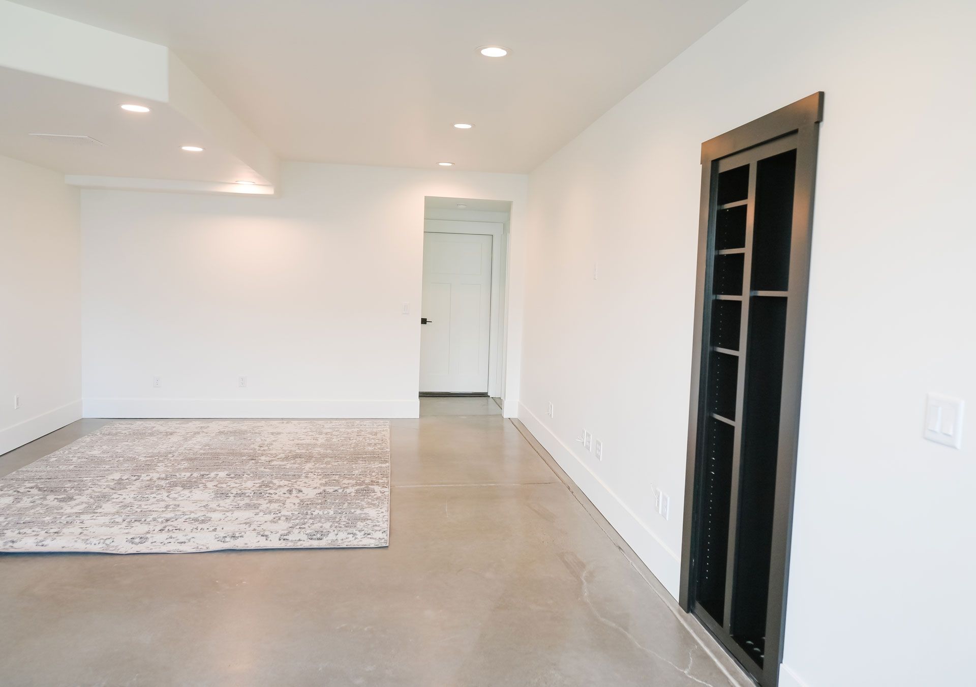 An empty room with a rug and a door.