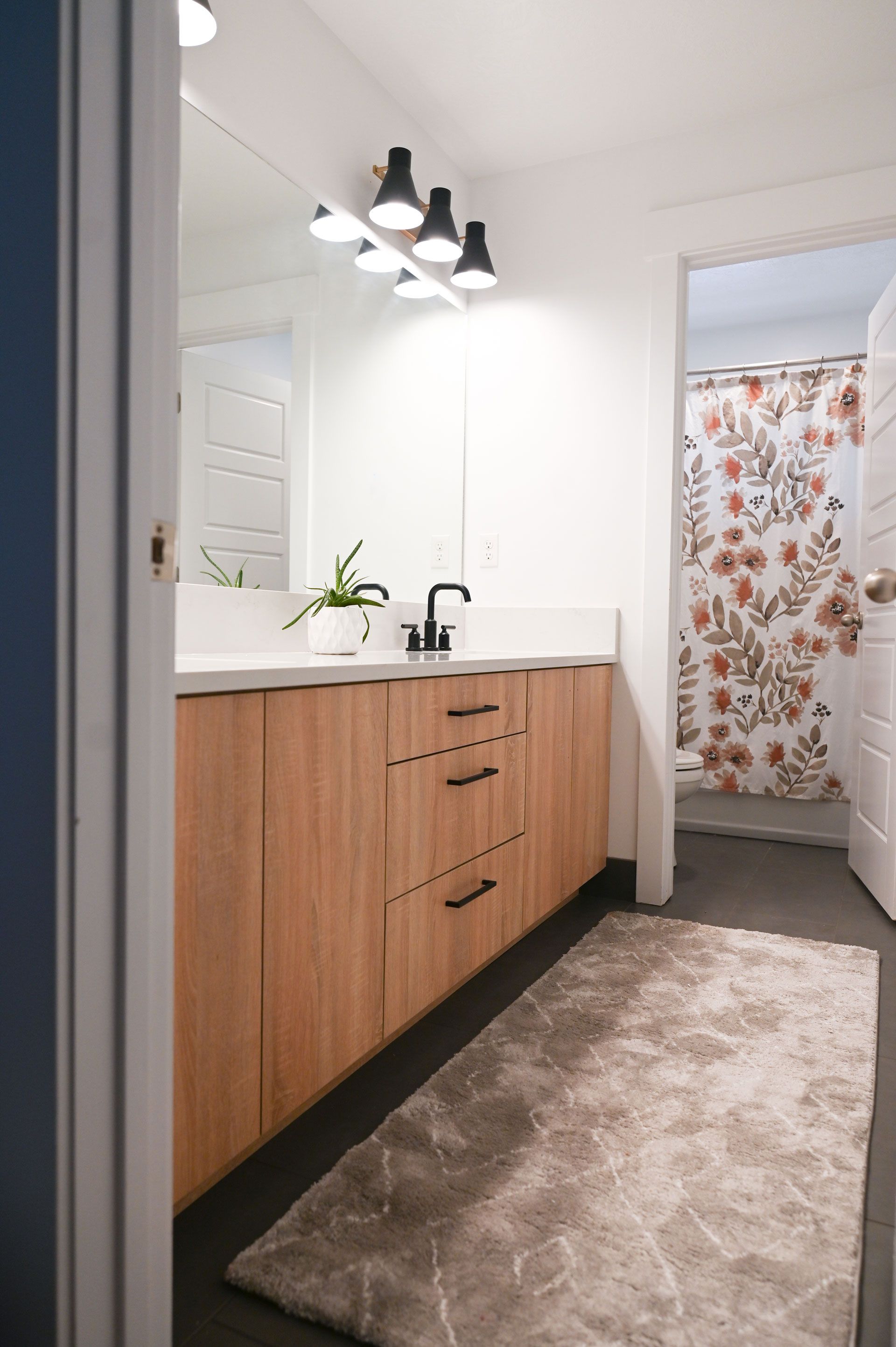 A bathroom with a sink , mirror and shower curtain.
