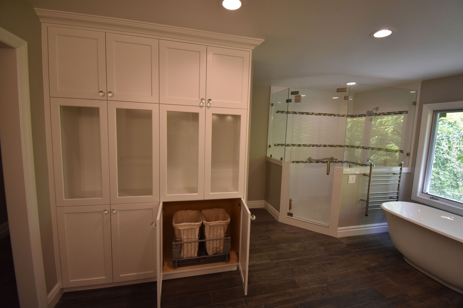 A bathroom with white cabinets and a bathtub.