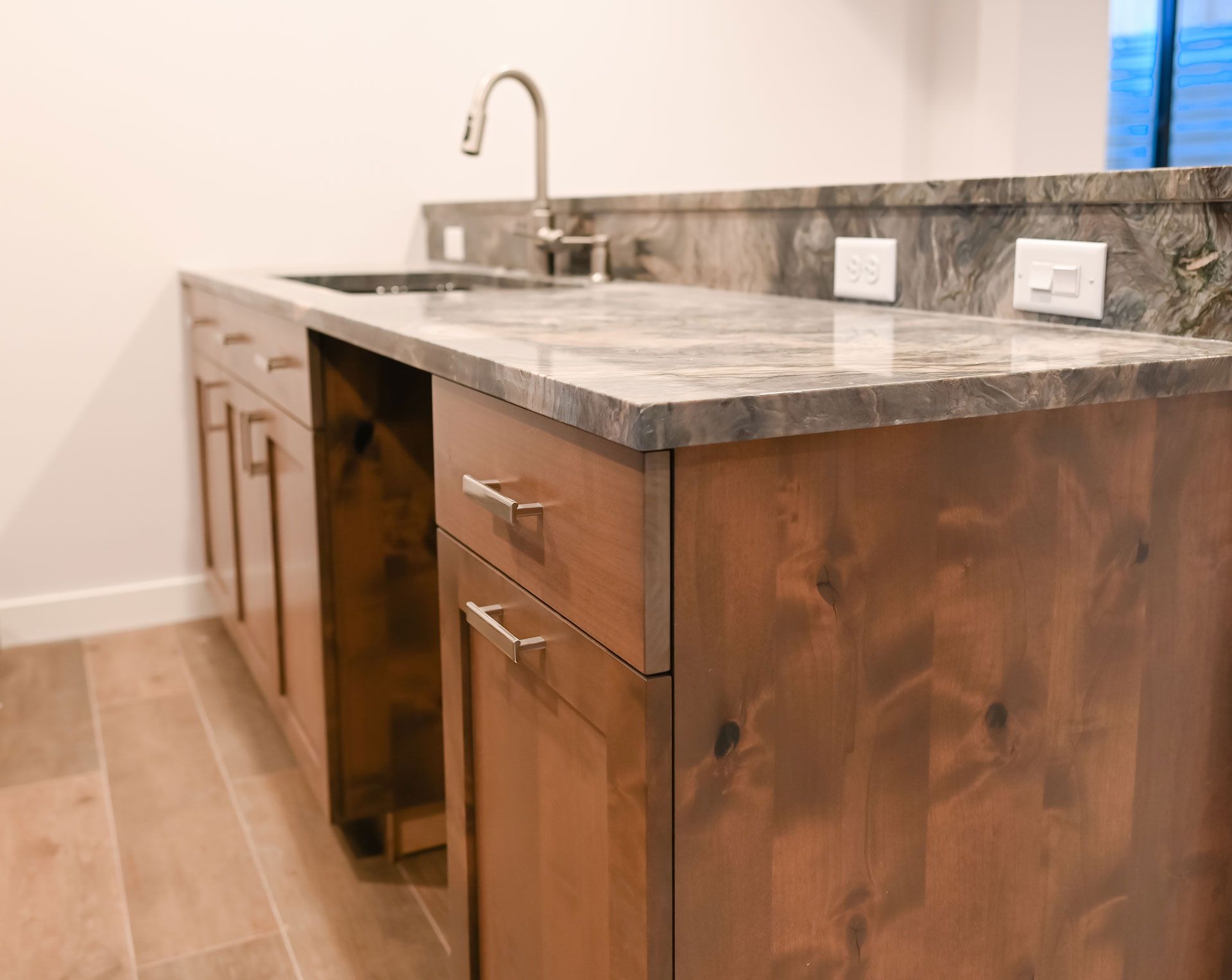 A kitchen with wooden cabinets , granite counter tops , and a sink.
