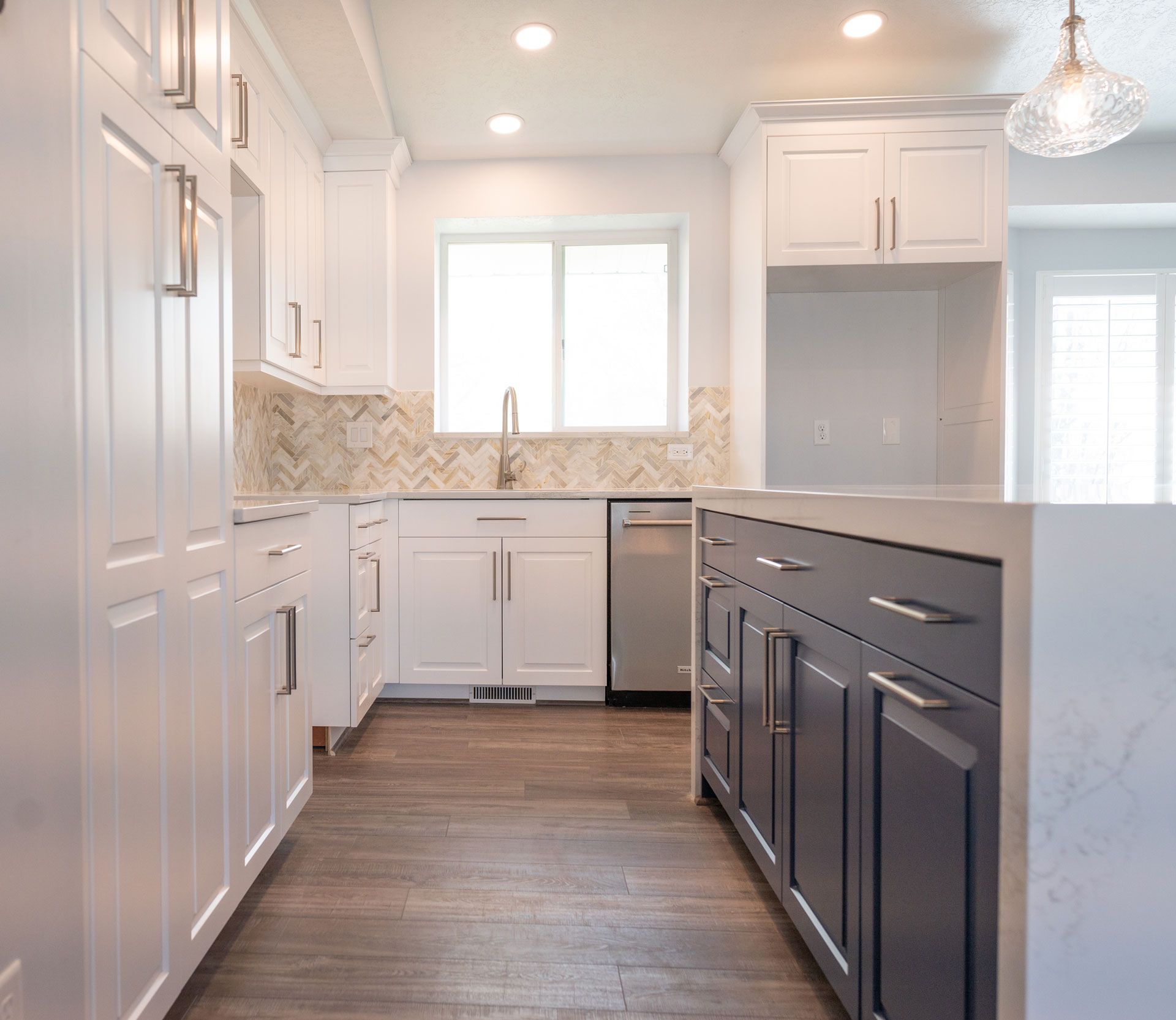 A kitchen with white cabinets and a stainless steel dishwasher.