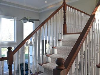 A staircase with a carpeted staircase and a wooden railing