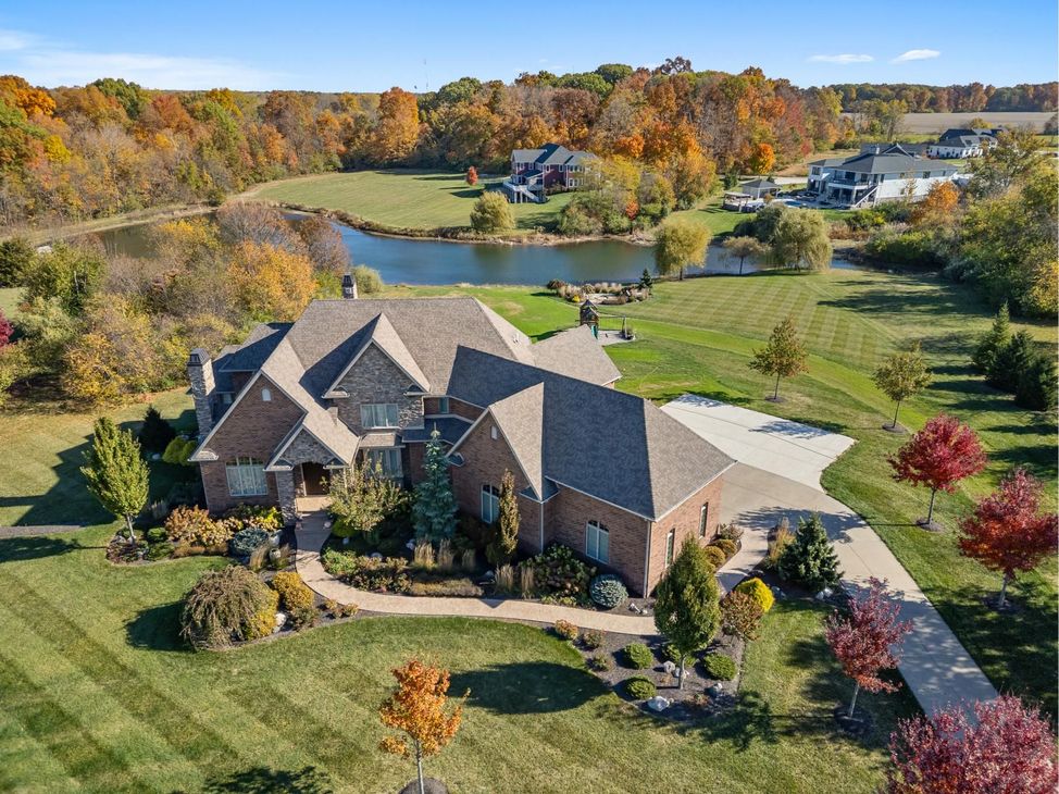 A living room with a stone fireplace and a ceiling fan