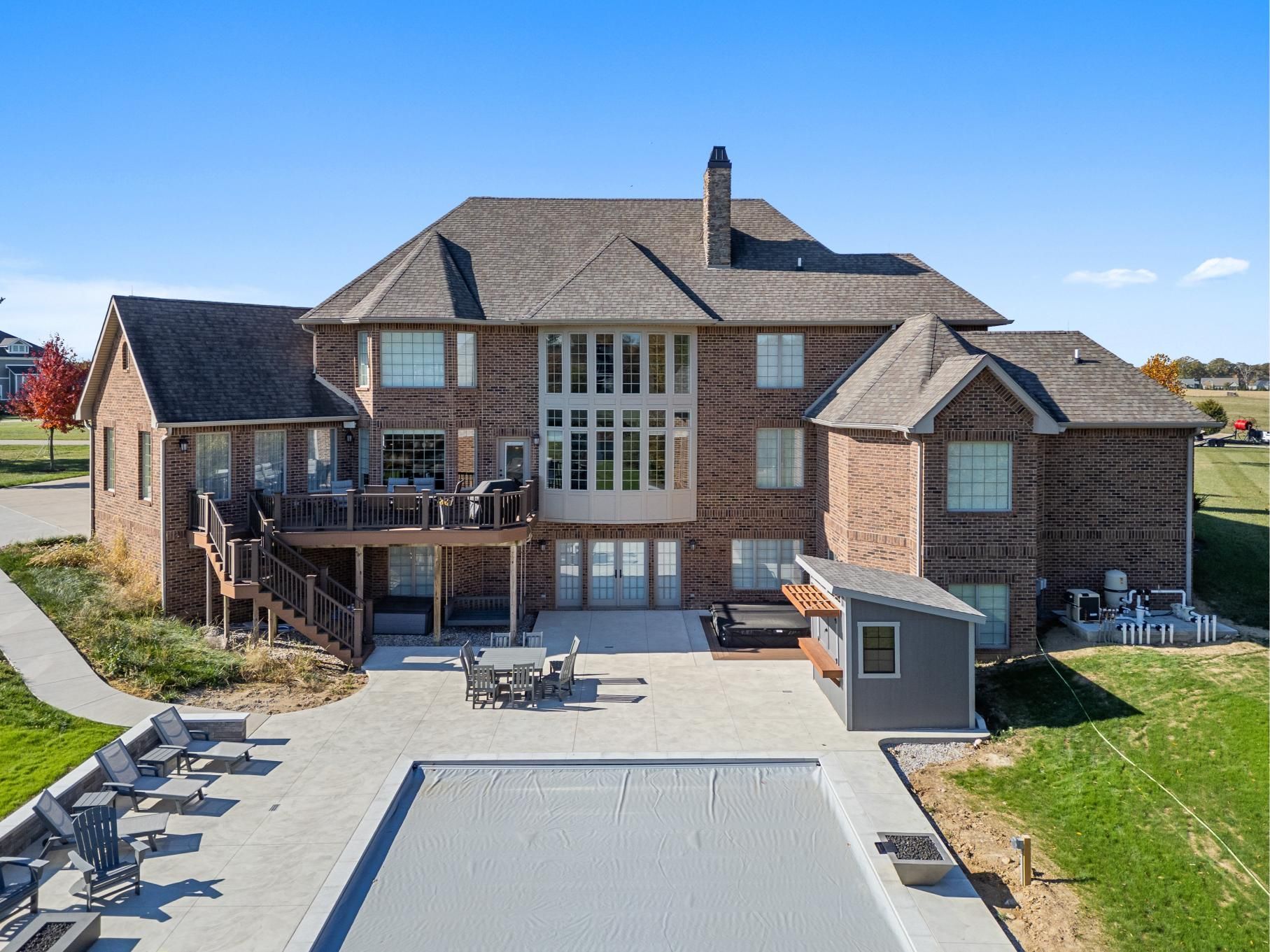A large house with a lush green lawn and a sidewalk in front of it.