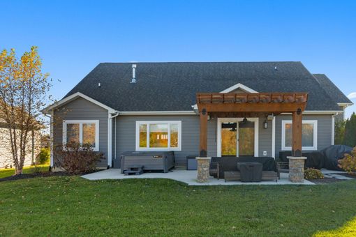 A large house is being built in a field with green siding.