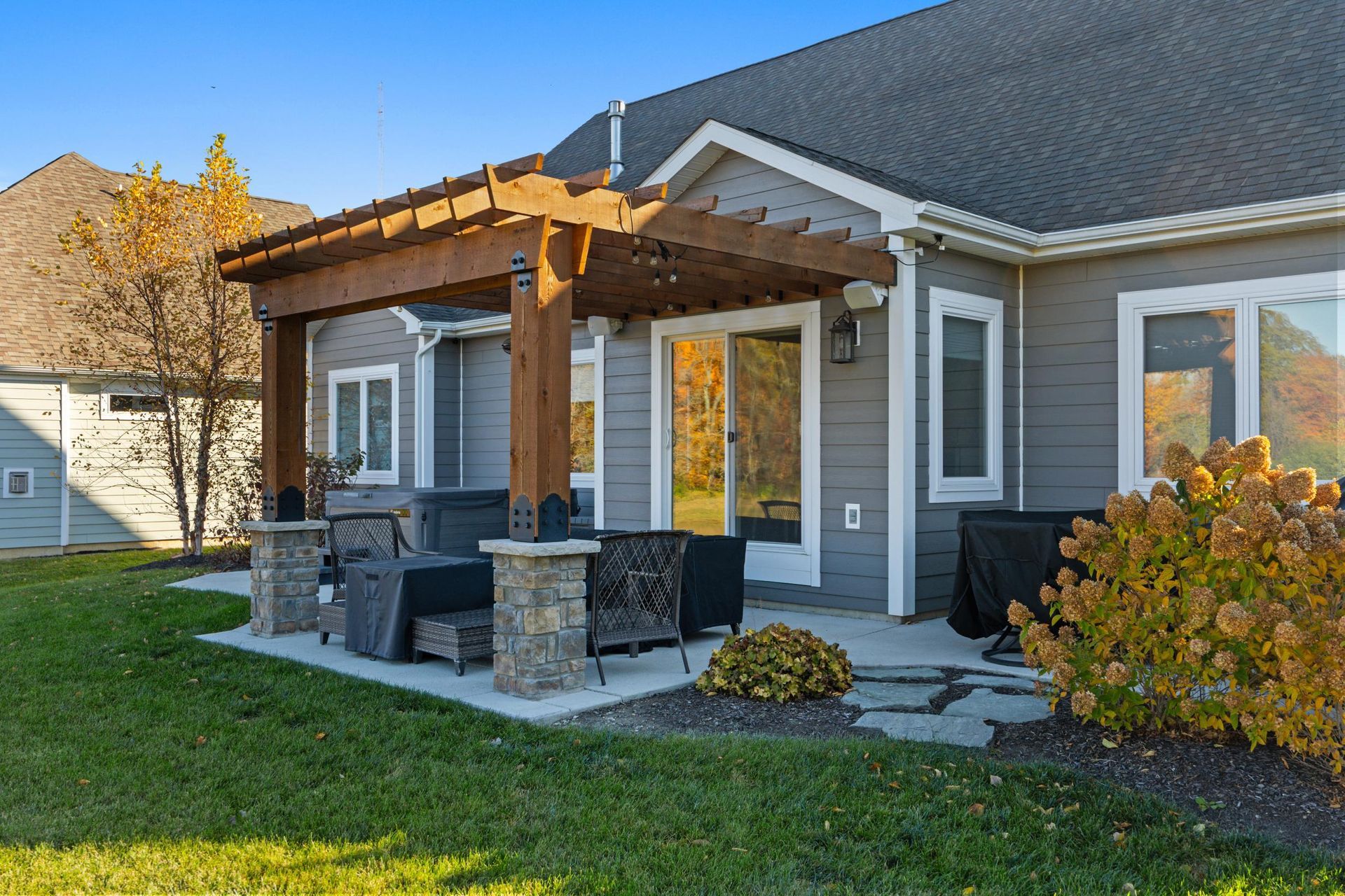 A white house with a gray garage door and a driveway