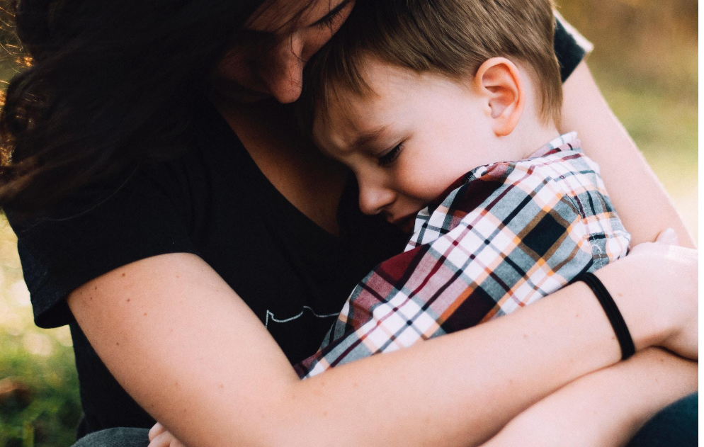 A woman is holding a little boy in her arms.