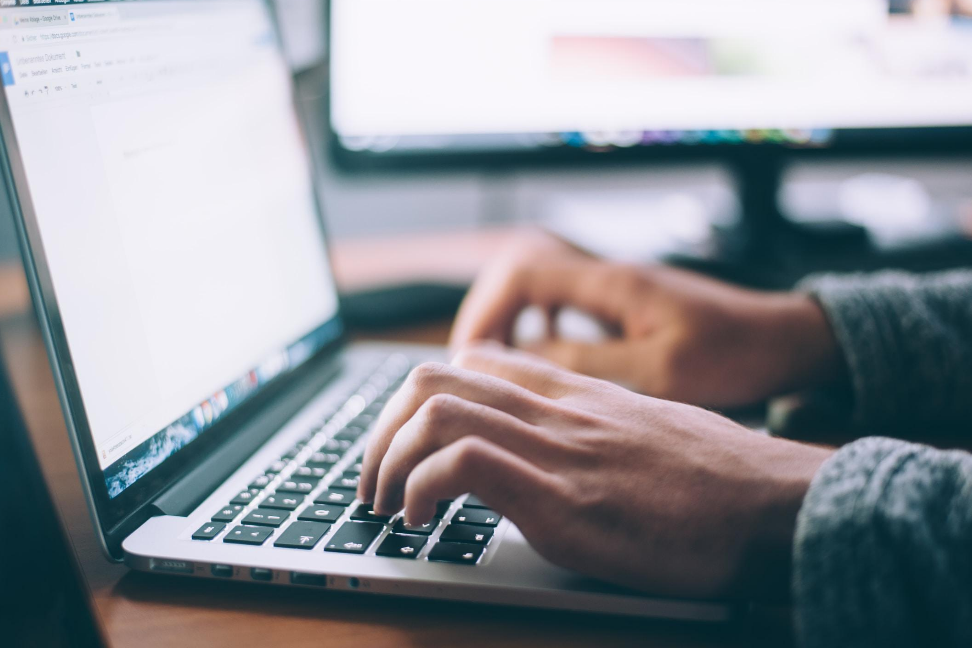 A person is typing on a laptop computer.