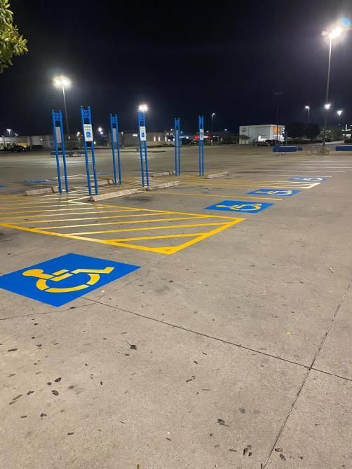 A handicapped parking spot in a parking lot at night