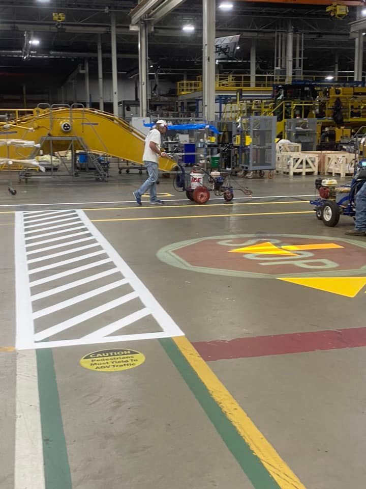 A man is pushing a tow truck in a warehouse
