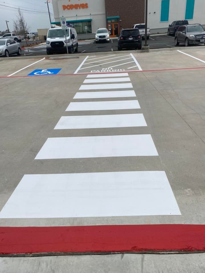 A white crosswalk is painted in a parking lot