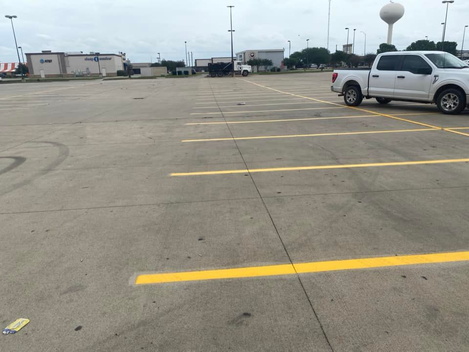 A white truck is parked in an empty parking lot
