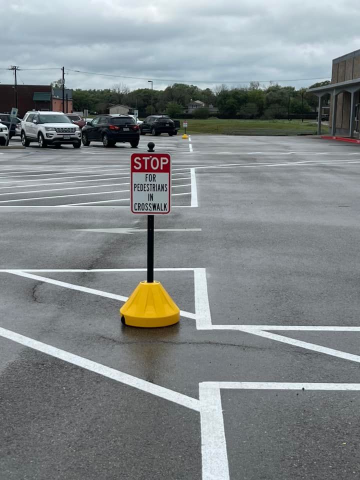 A stop sign is in the middle of a parking lot