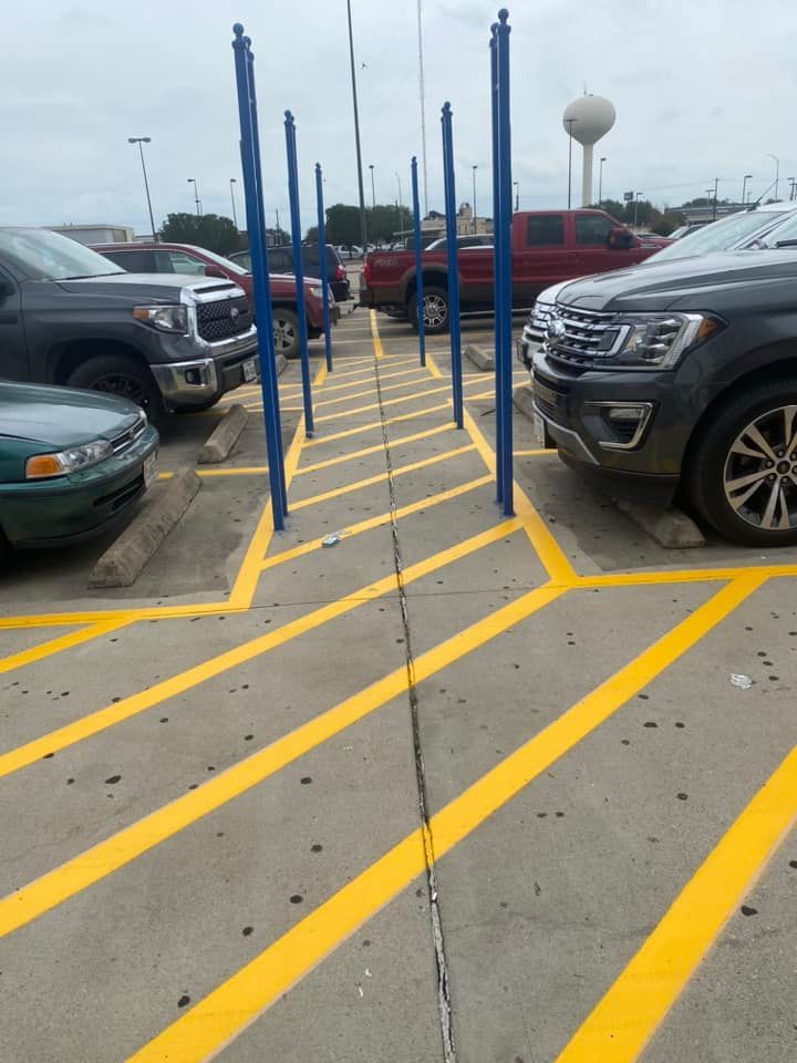 Several cars are parked in a parking lot with yellow lines