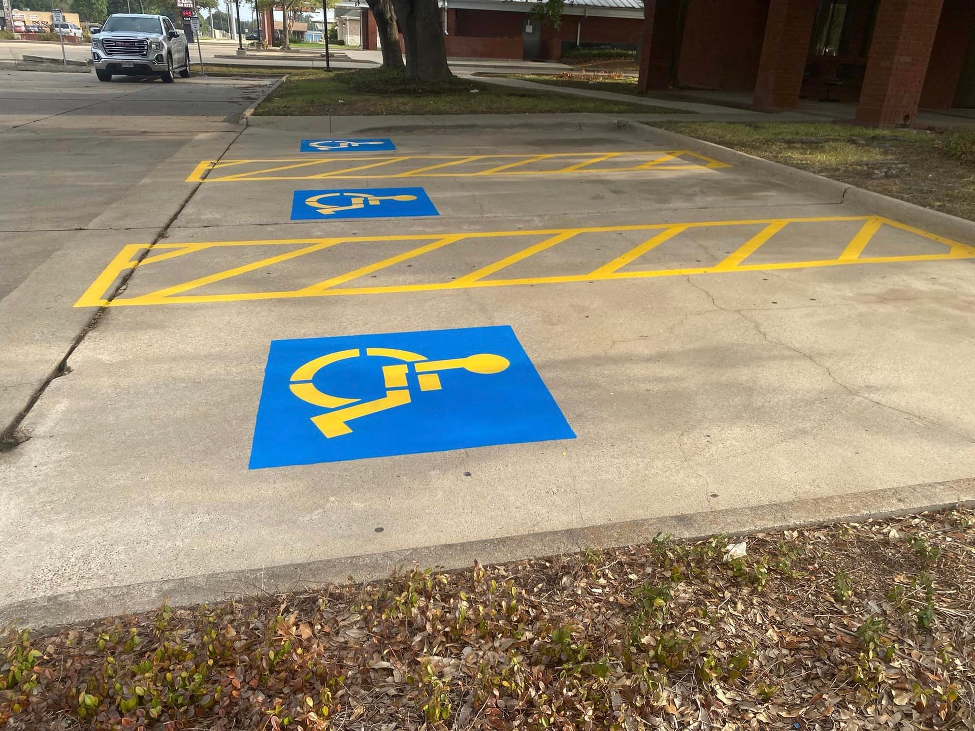 A row of handicapped parking spaces painted blue and yellow