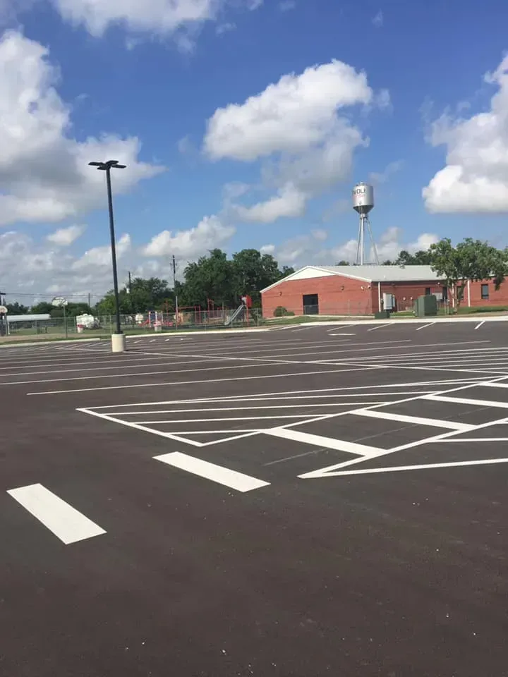 An empty parking lot with a water tower in the background